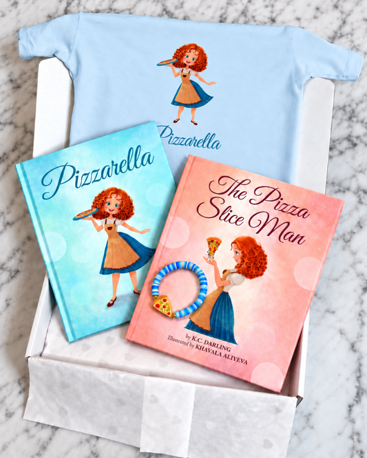 A gift set in a white box, featuring a light blue t-shirt, a hardcover book titled 'Pizzarella', a children's book titled 'The Pizza Slice Man', and a blue and white bracelet.