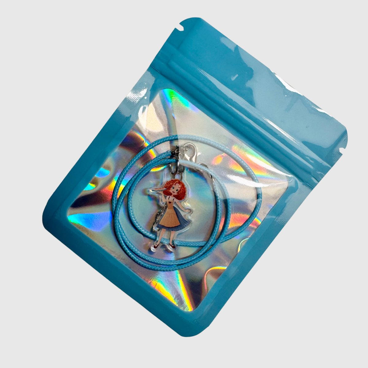 Blue lanyard with a pendant in a clear plastic package on a light gray background