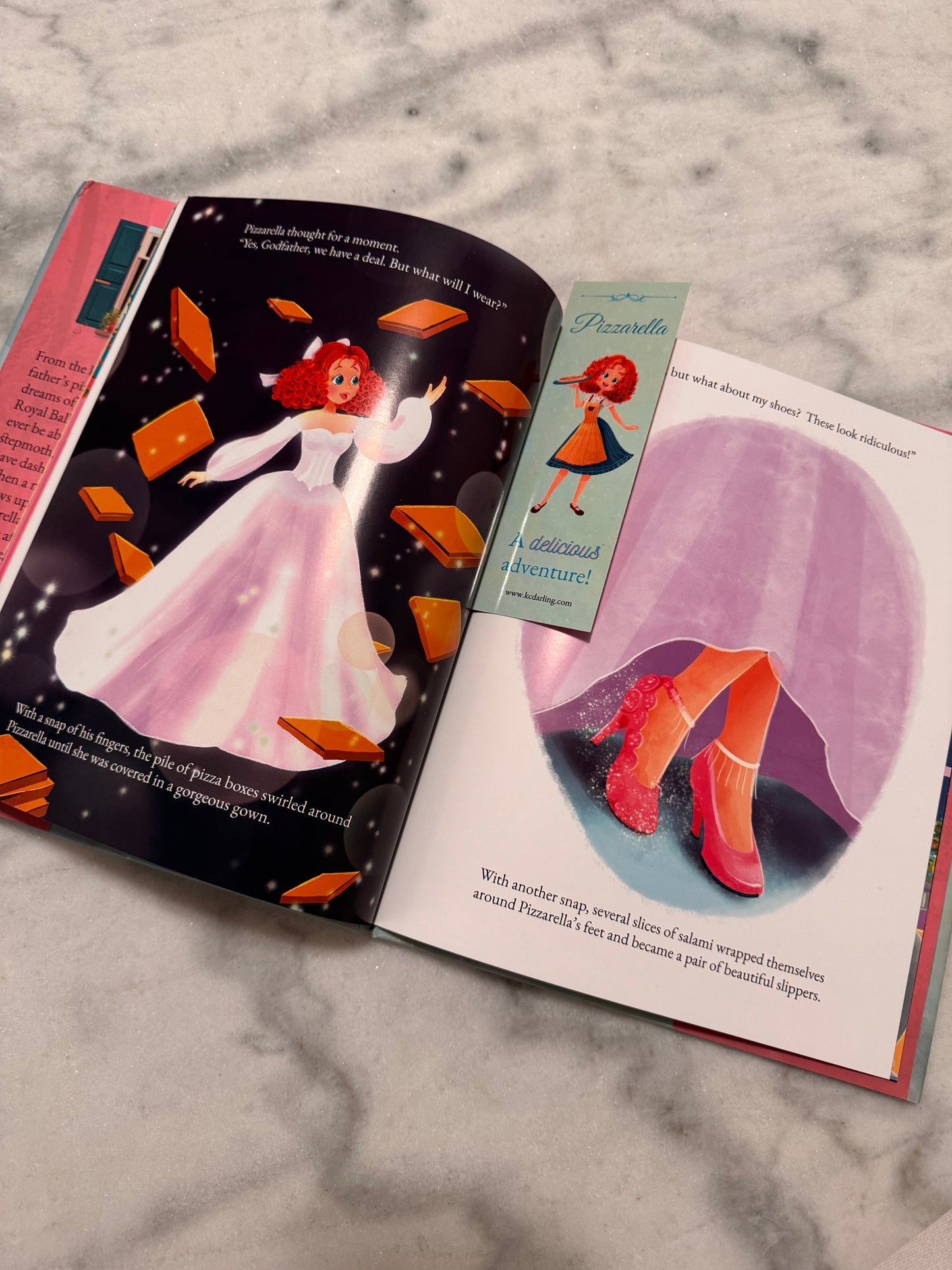 Open book with illustrations of a princess and a cat on a marble surface
