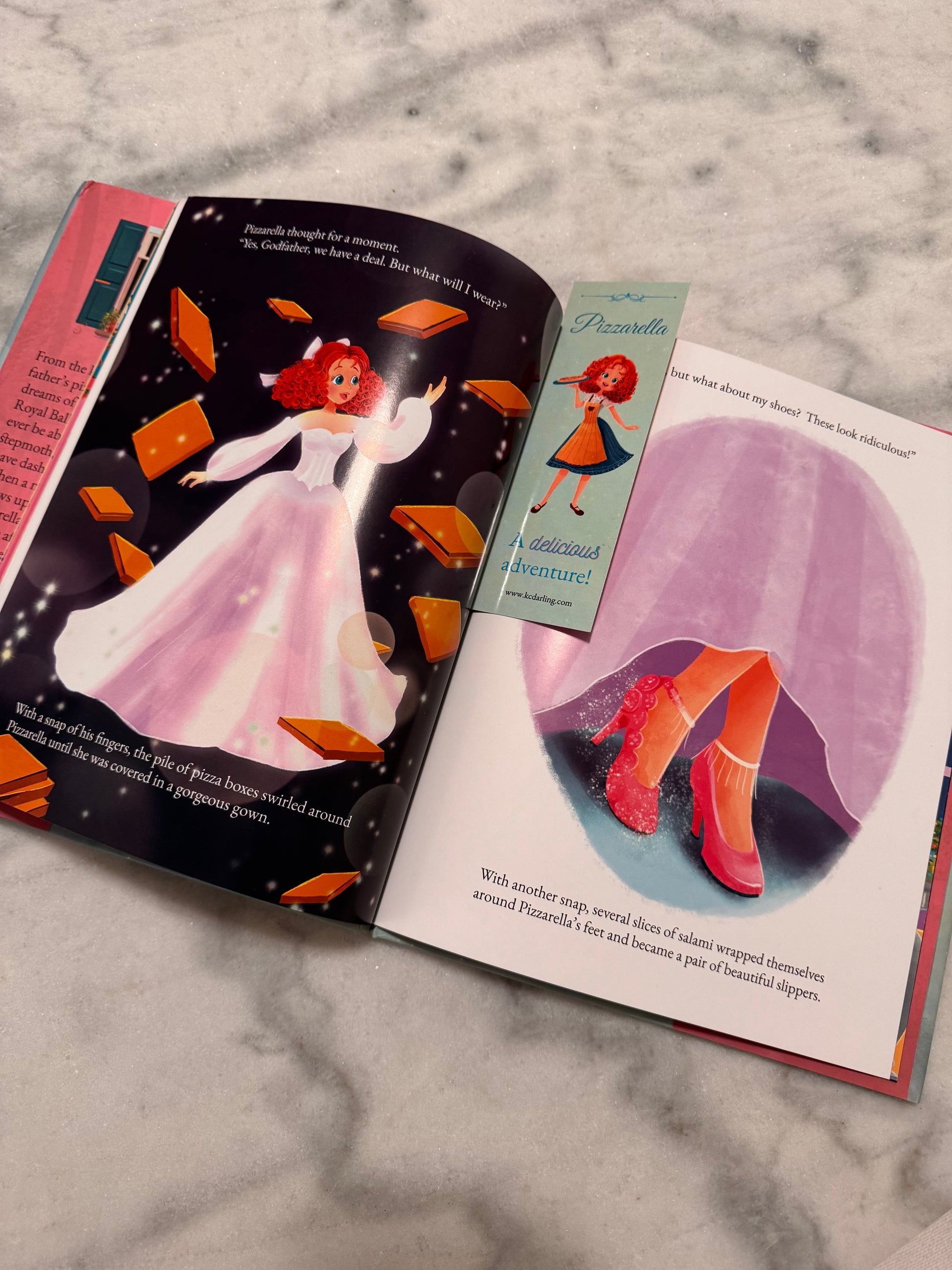 Open book with illustrations of a princess and a cat on a marble surface